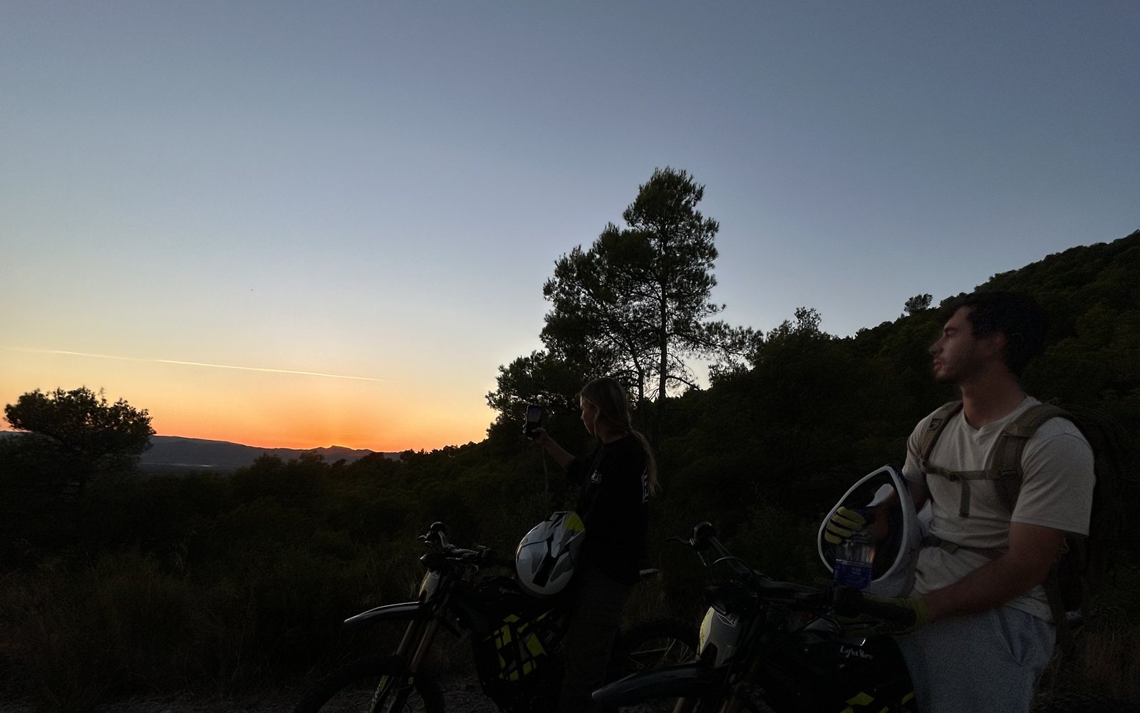 Two riders on Surron electric dirt bikes at sunset on the private estate near Tarragona